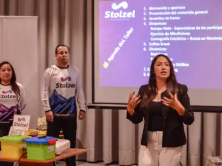 Facilitadores de Stolzel presentando la agenda del taller frente a la pantalla.