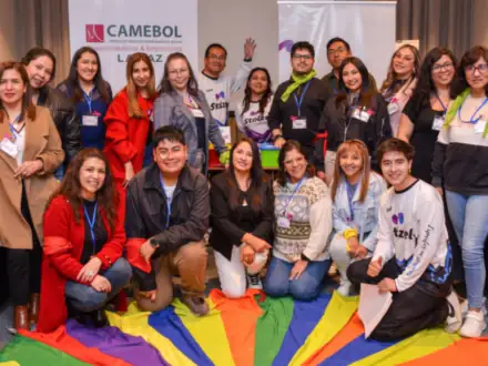 Grupo completo del taller posando sobre un paracaídas de colores.
